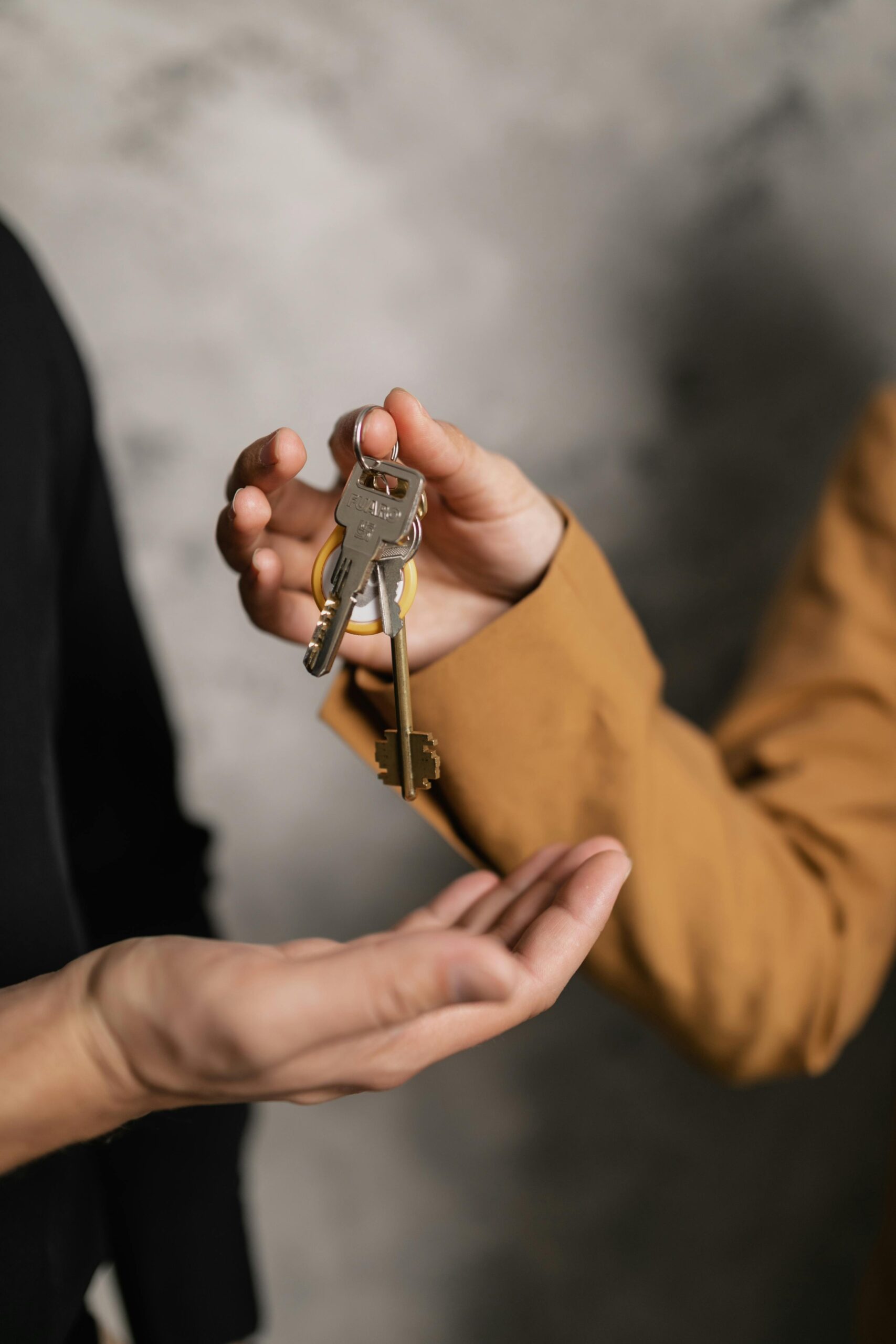 pexels photo 7642004 7642004 Two adults exchanging house keys, symbolic of property transfer or rental agreement.